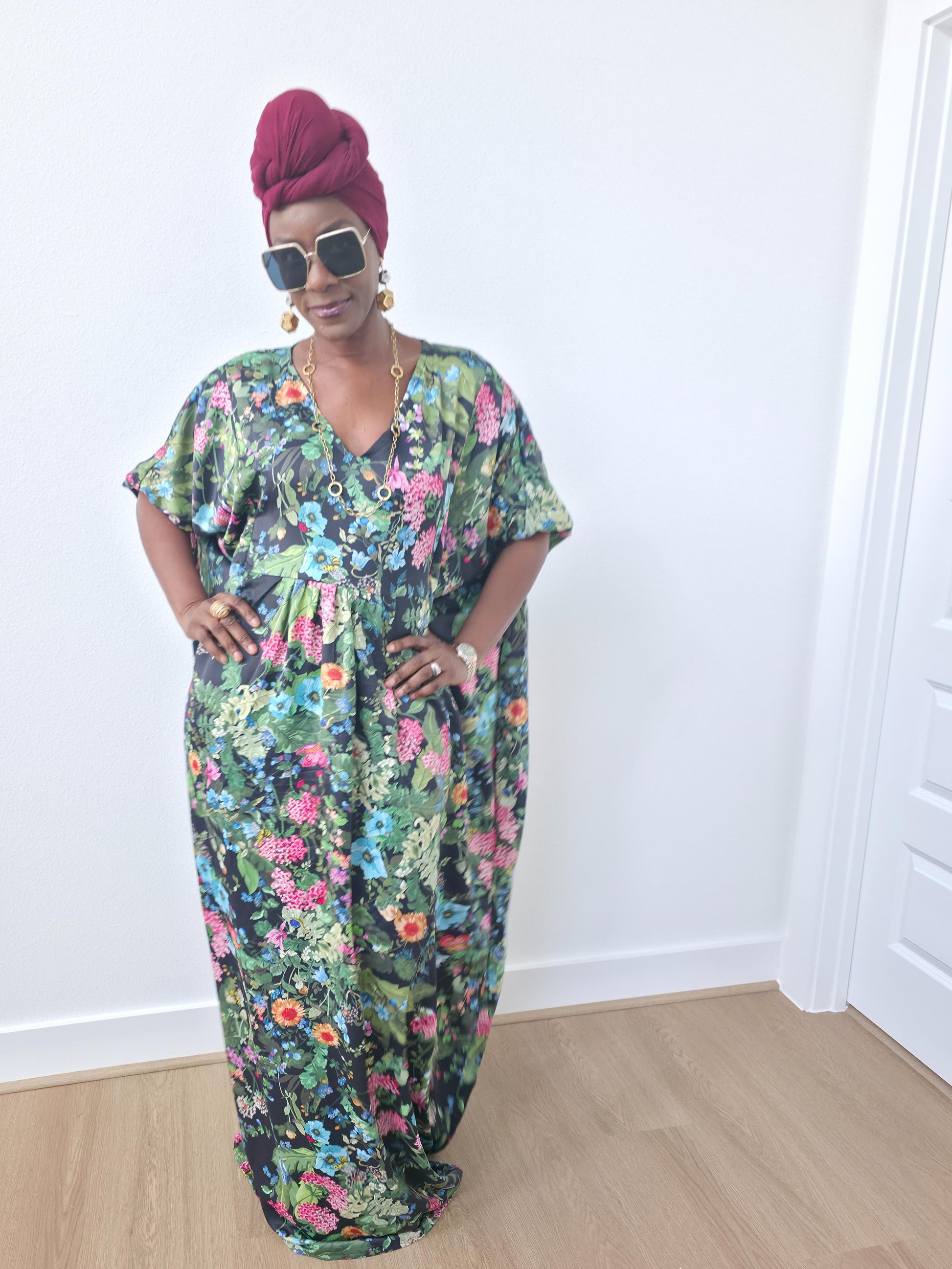 Green floral boubou kaftan featuring a vibrant pink and blue botanical pattern with a flowing, floor-length silhouette.-Front View