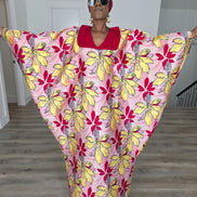 Hibiscus Sorbet Boubou Kaftan featuring a light pink fabric with large yellow and red floral prints and a structured deep red V-neck collar. Front View