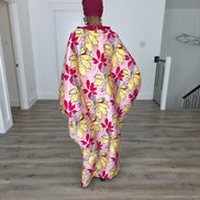 Hibiscus Sorbet Boubou Kaftan featuring a light pink fabric with large yellow and red floral prints and a structured deep red V-neck collar. Back View