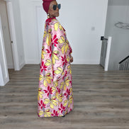 Hibiscus Sorbet Boubou Kaftan featuring a light pink fabric with large yellow and red floral prints and a structured deep red V-neck collar. Side View 