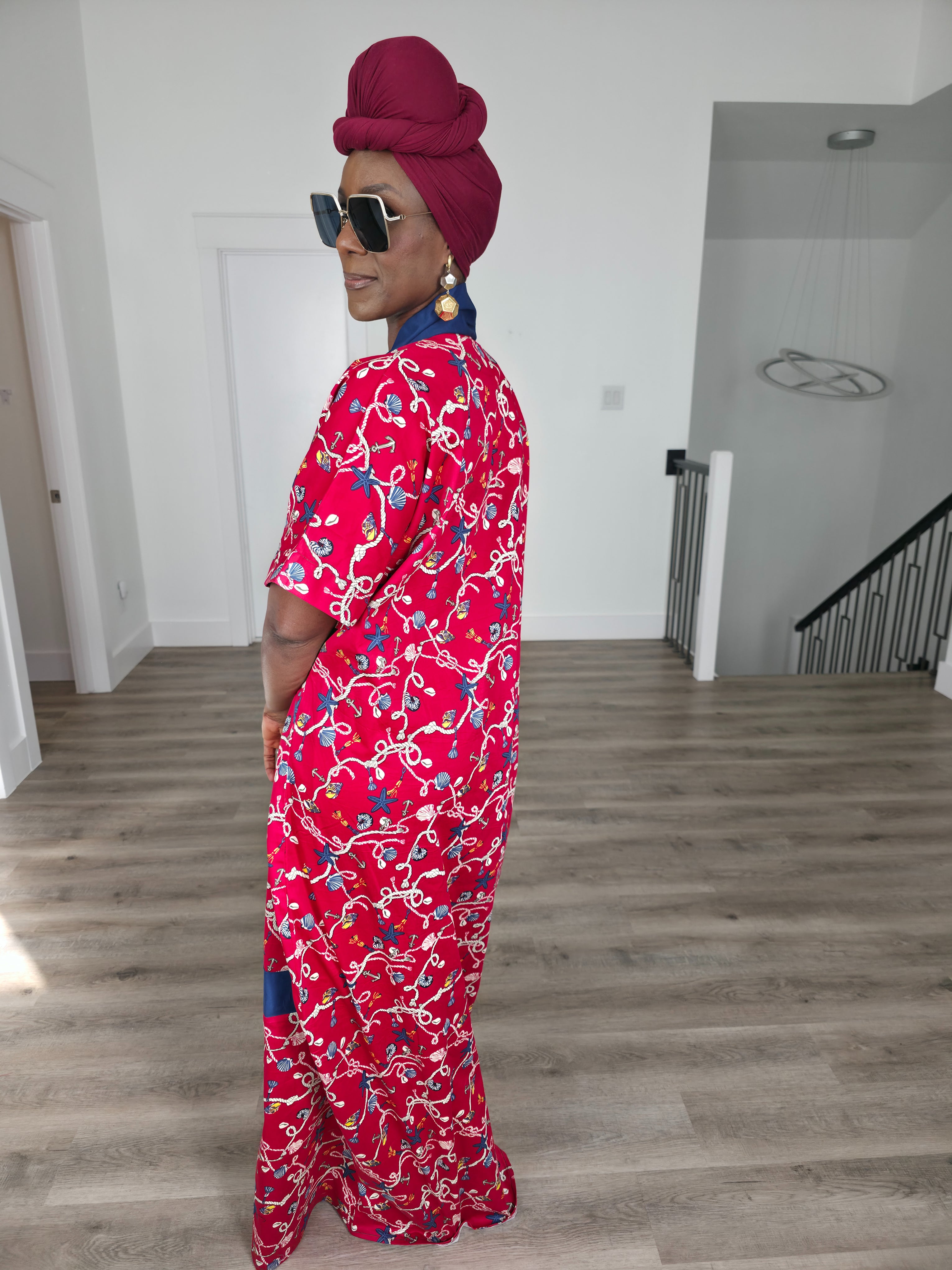 Midnight Poppy Boubou Kaftan in deep red with a white and blue floral print, featuring a navy blue collar and matching burgundy headwrap. Side back view