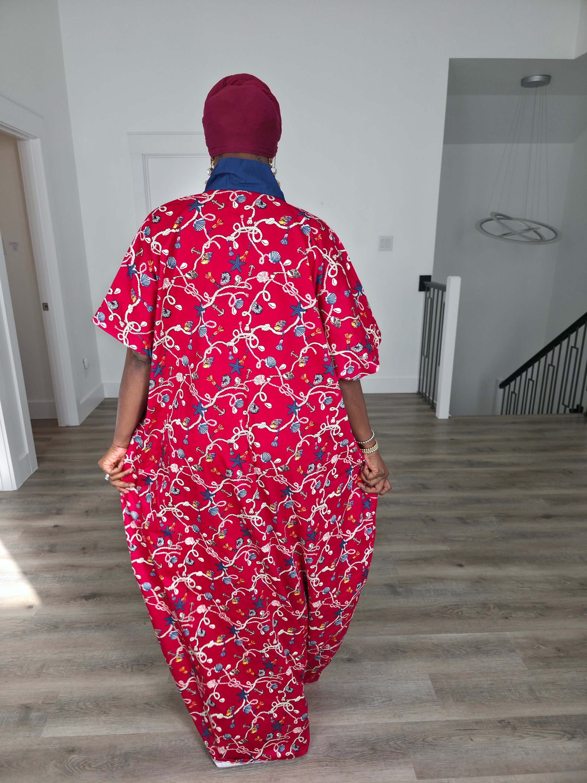 Midnight Poppy Boubou Kaftan in deep red with a white and blue floral print, featuring a navy blue collar and matching burgundy headwrap. Back View