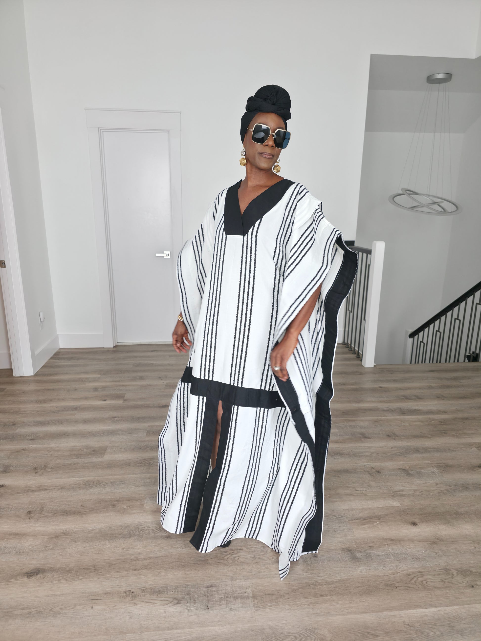Obsidian Grid Boubou Kaftan featuring a black and white vertical stripe pattern with bold black structural borders and a matching black headwrap. Front View