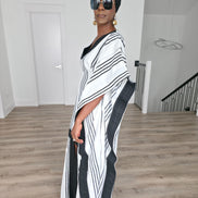 Obsidian Grid Boubou Kaftan featuring a black and white vertical stripe pattern with bold black structural borders and a matching black headwrap. Side View