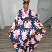 Painted Twilight Boubou Kaftan in deep navy blue featuring large, abstract pink and orange floral prints with a soft pink V-neck collar. Front View