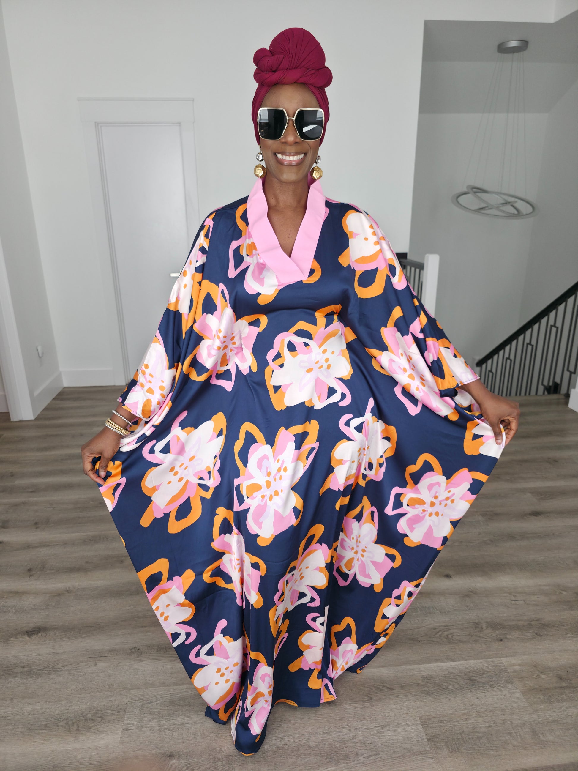 Painted Twilight Boubou Kaftan in deep navy blue featuring large, abstract pink and orange floral prints with a soft pink V-neck collar. Front View