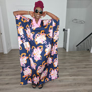 Painted Twilight Boubou Kaftan in deep navy blue featuring large, abstract pink and orange floral prints with a soft pink V-neck collar. Women's Wear