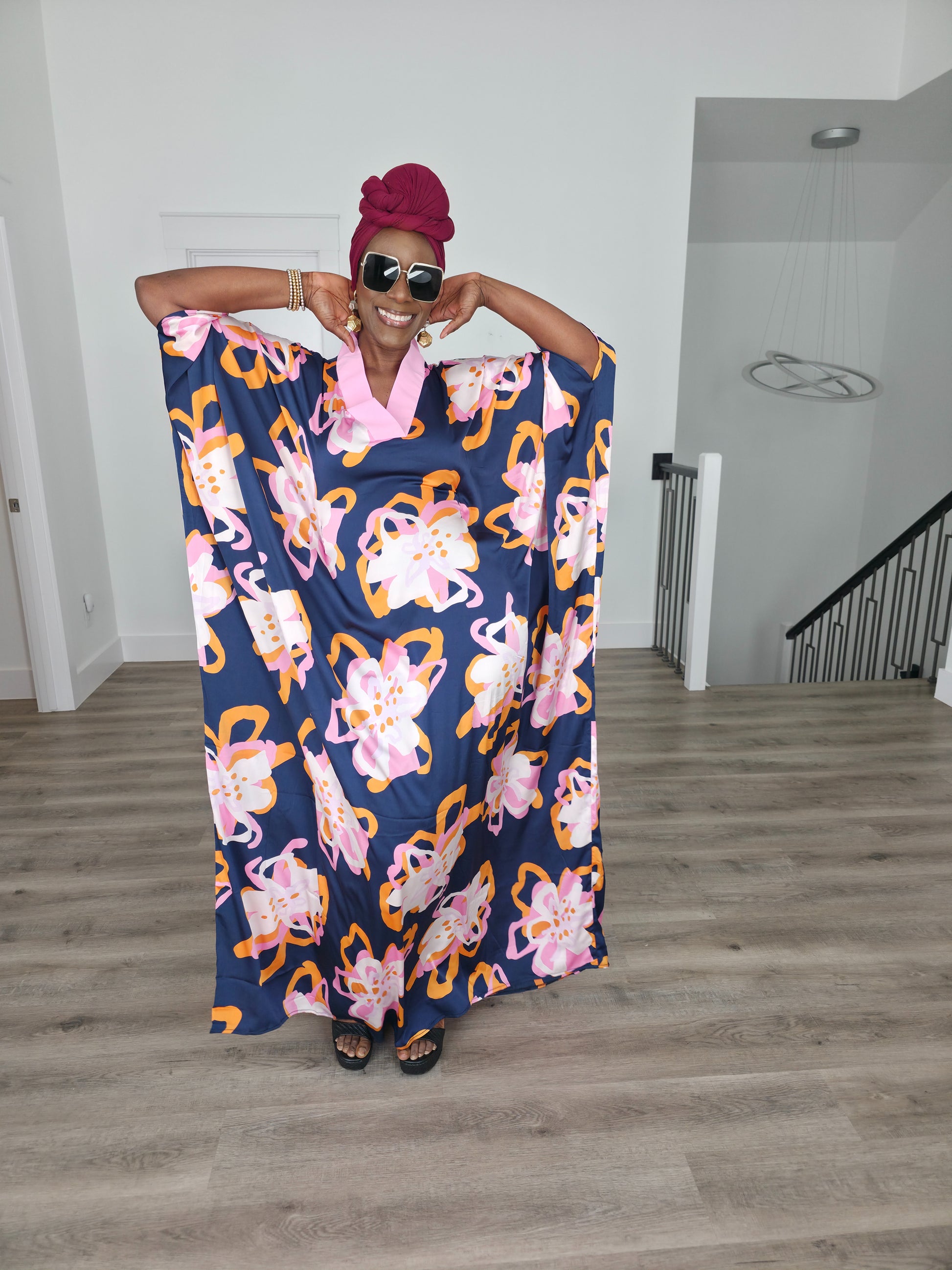 Painted Twilight Boubou Kaftan in deep navy blue featuring large, abstract pink and orange floral prints with a soft pink V-neck collar. Women's Wear