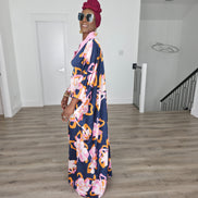 Painted Twilight Boubou Kaftan in deep navy blue featuring large, abstract pink and orange floral prints with a soft pink V-neck collar. Side Profile