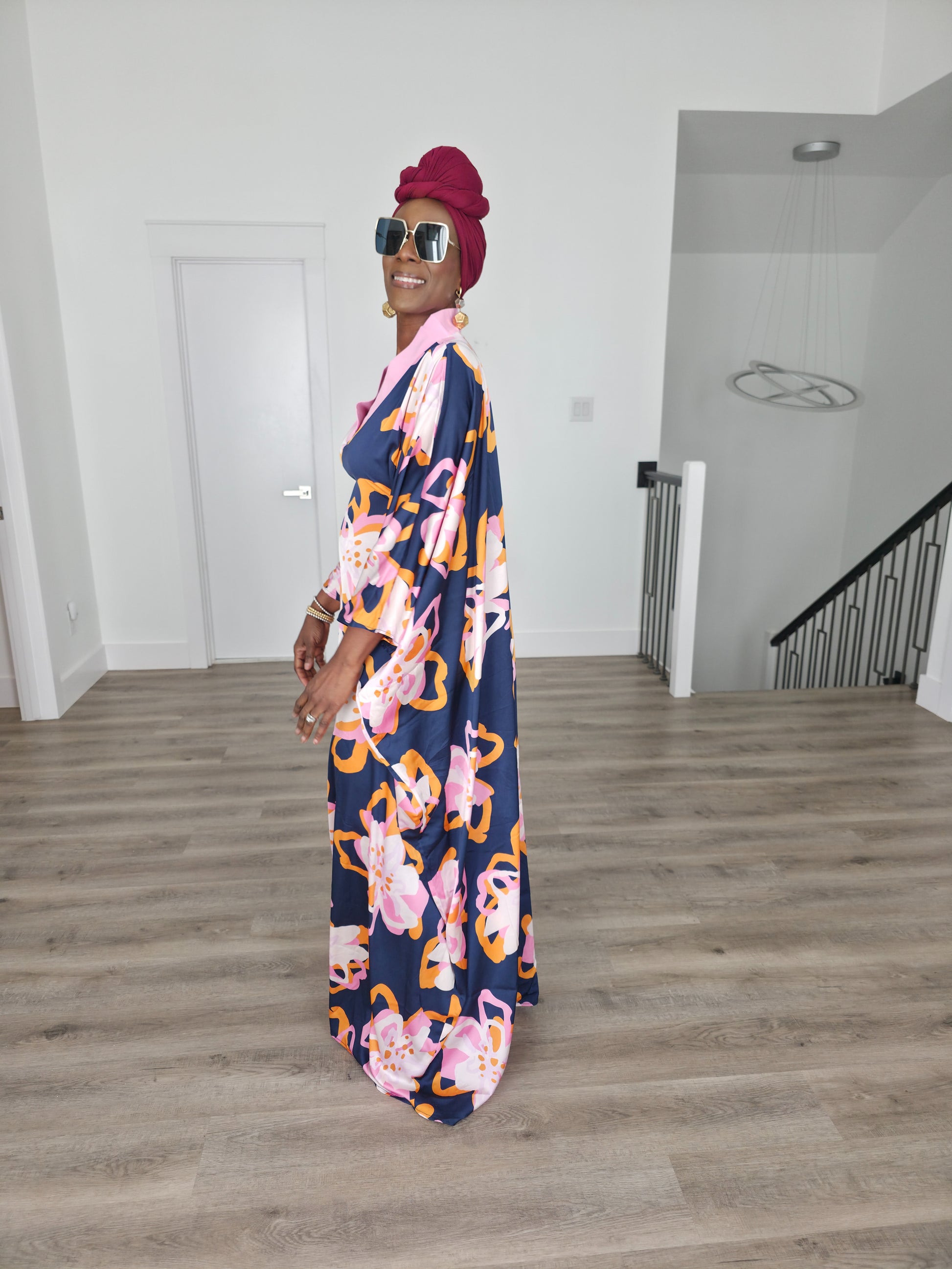 Painted Twilight Boubou Kaftan in deep navy blue featuring large, abstract pink and orange floral prints with a soft pink V-neck collar. Side Profile