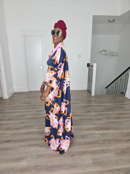 Painted Twilight Boubou Kaftan in deep navy blue featuring large, abstract pink and orange floral prints with a soft pink V-neck collar. Side Profile