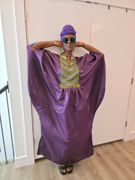 Luxury purple Boubou Kaftan featuring a heavily beaded green and gold bodice, wide sleeves, and a matching purple headwrap.