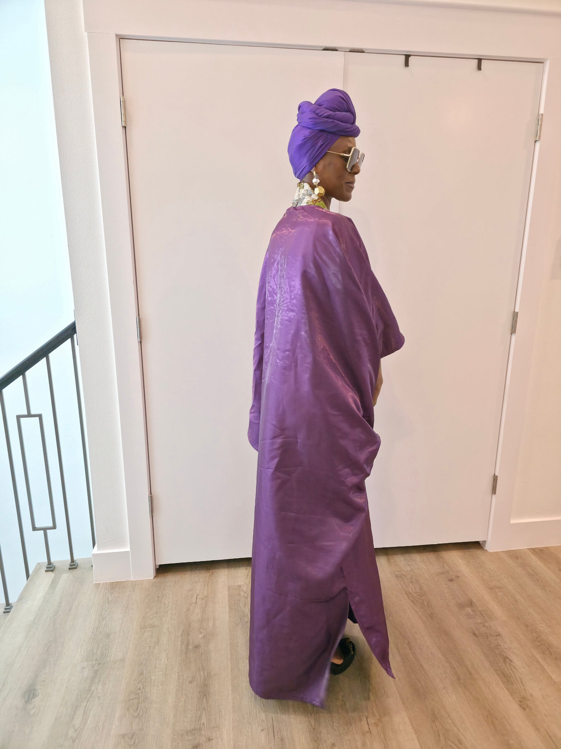 Luxury purple Boubou Kaftan featuring a heavily beaded green and gold bodice, wide sleeves, and a matching purple headwrap.