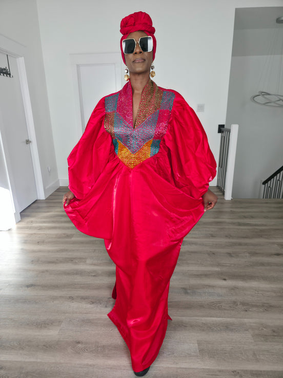 Rubied Prism Boubou Kaftan in vibrant red with a colorful geometric embroidered neckline and matching red headwrap. Front View