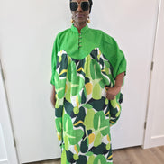 Kaftan featuring a floor-length flowing gown with a structured green bodice and a vibrant, multi-tonal botanical print. Front.