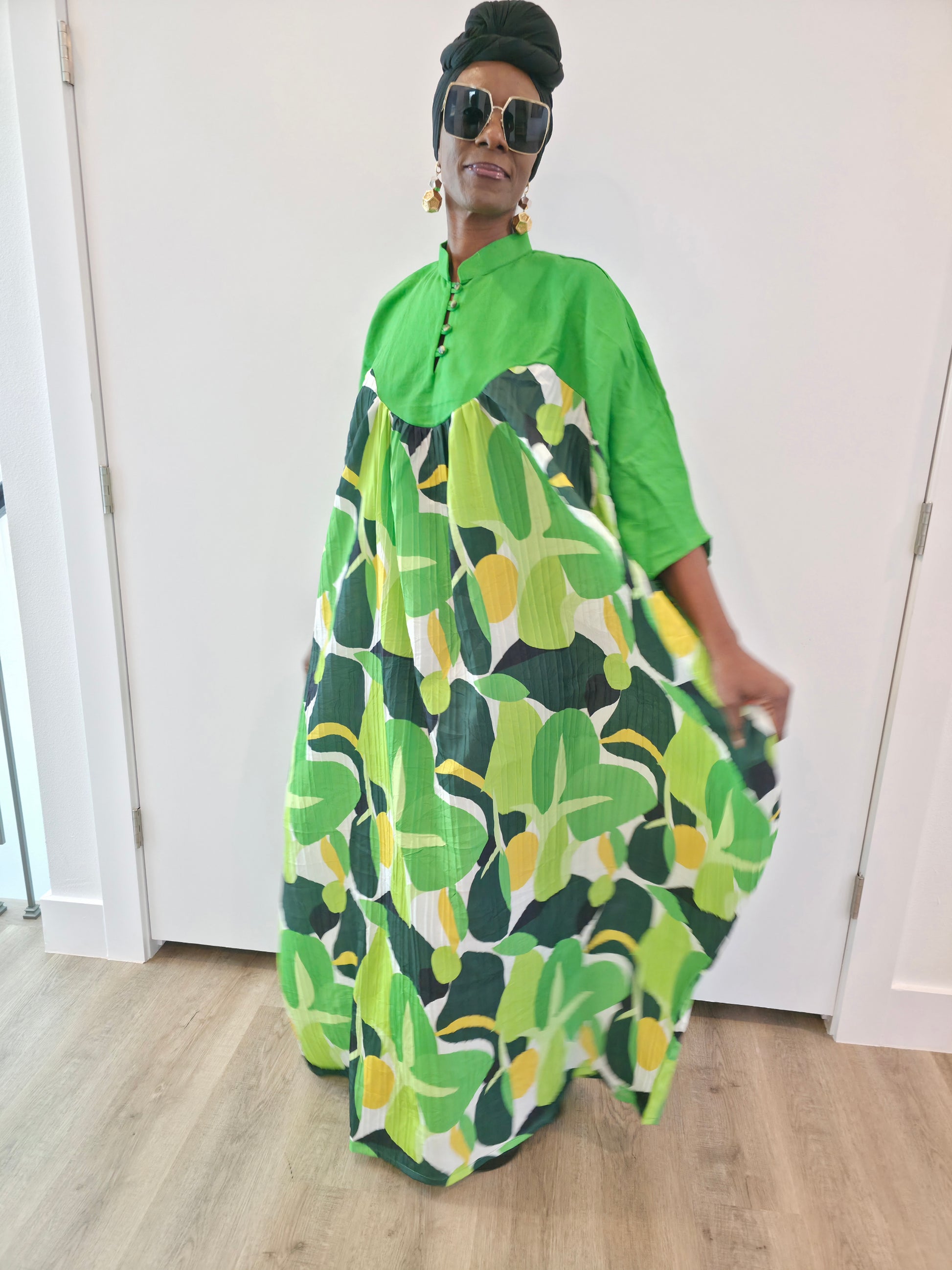 Kaftan featuring a floor-length flowing gown with a structured green bodice and a vibrant, multi-tonal botanical print.