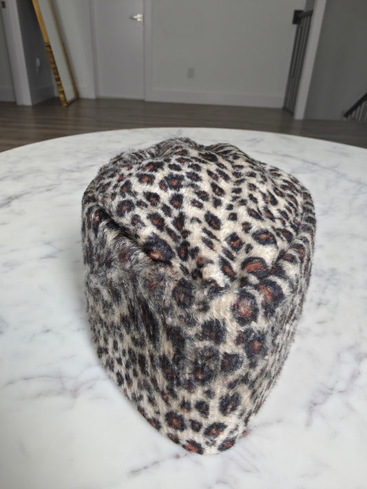 Afrocentric Kufi cap featuring a bold leopard animal print on a textured velvet fabric with a foldable, structured silhouette.