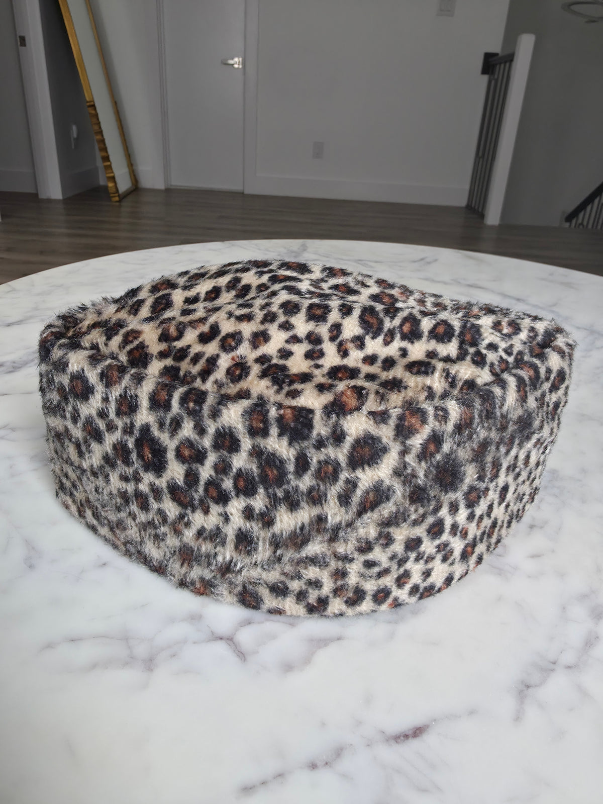 Afrocentric Kufi cap featuring a bold leopard animal print on a textured velvet fabric with a foldable, structured silhouette.