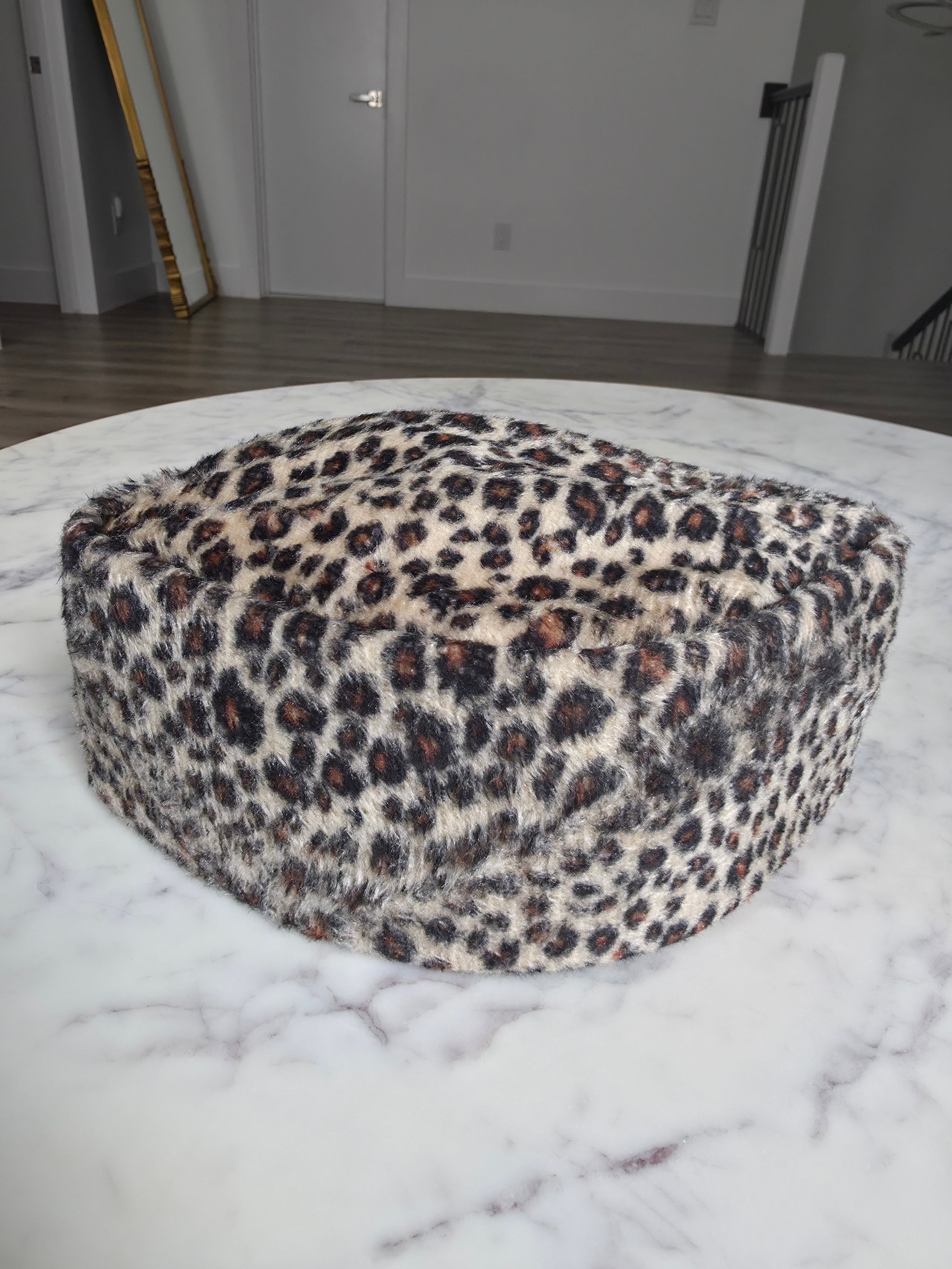 Afrocentric Kufi cap featuring a bold leopard animal print on a textured velvet fabric with a foldable, structured silhouette.
