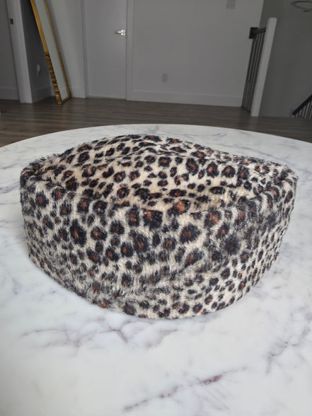 Afrocentric Kufi cap featuring a bold leopard animal print on a textured velvet fabric with a foldable, structured silhouette.
