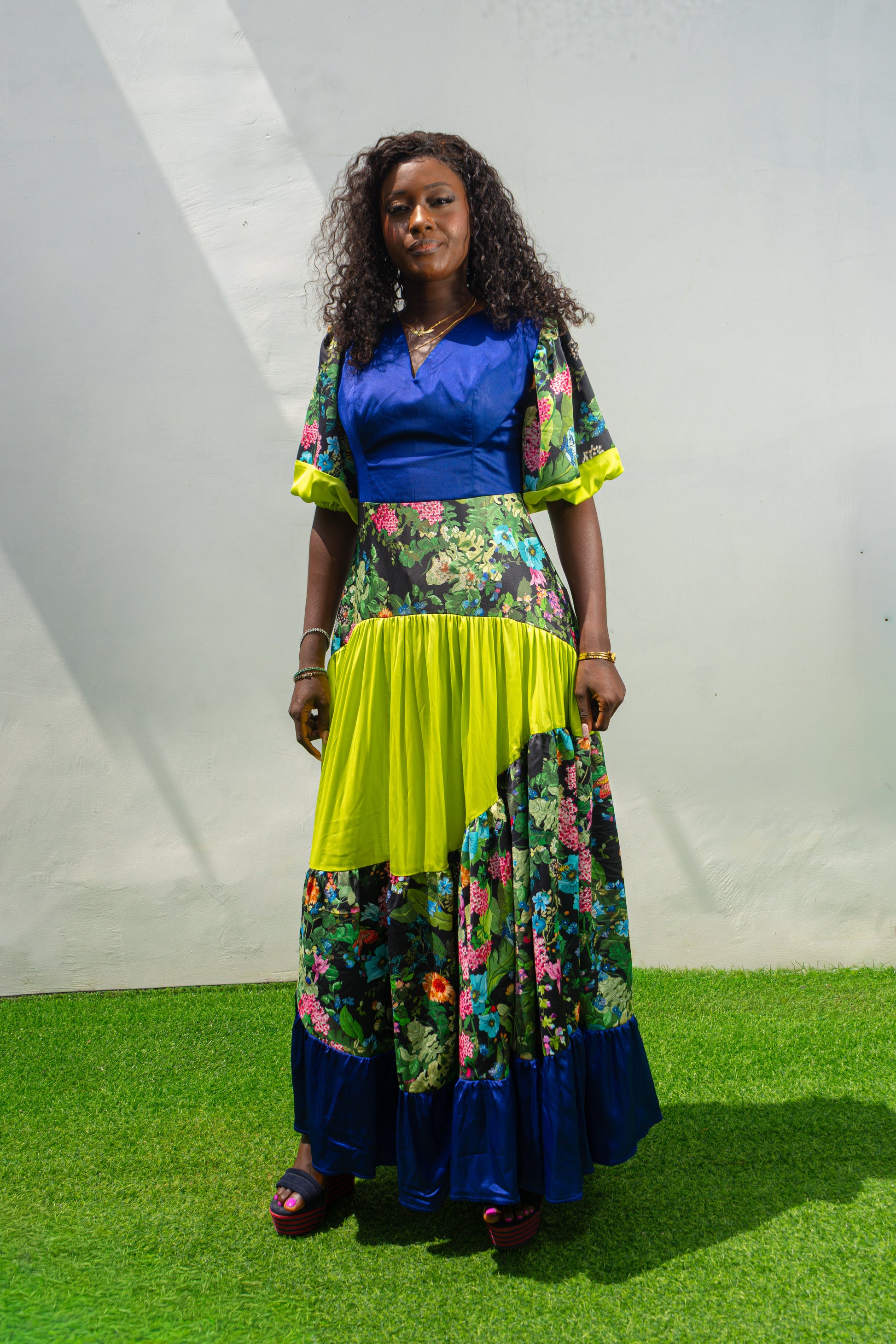 Maxi Dress featuring a solid blue V-neck bodice, floral print sleeves and skirt, and vibrant lime green tiered accents.