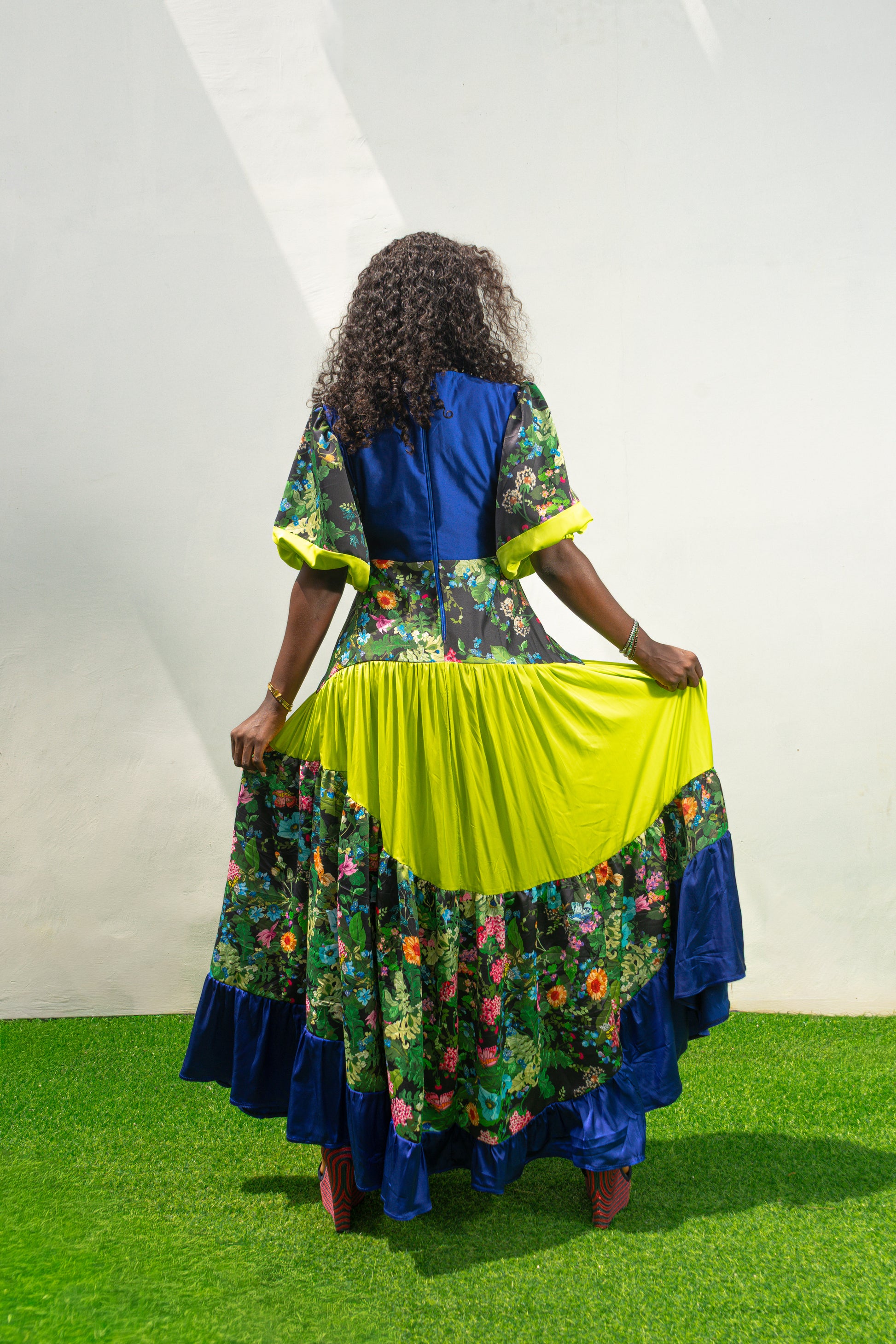 Maxi Dress featuring a solid blue V-neck bodice, floral print sleeves and skirt, and vibrant lime green tiered accents. Back View