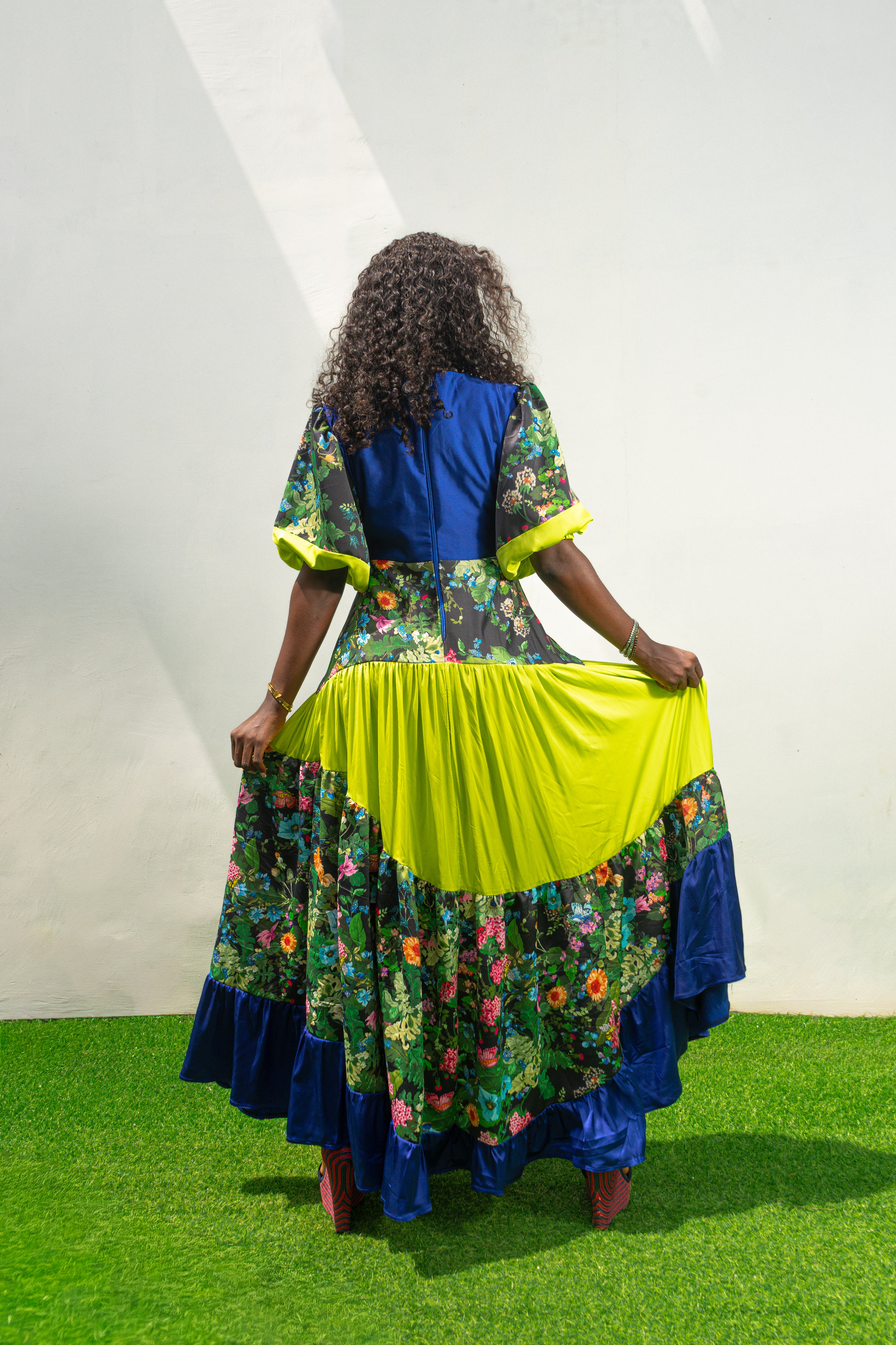 Maxi Dress featuring a solid blue V-neck bodice, floral print sleeves and skirt, and vibrant lime green tiered accents. Back View