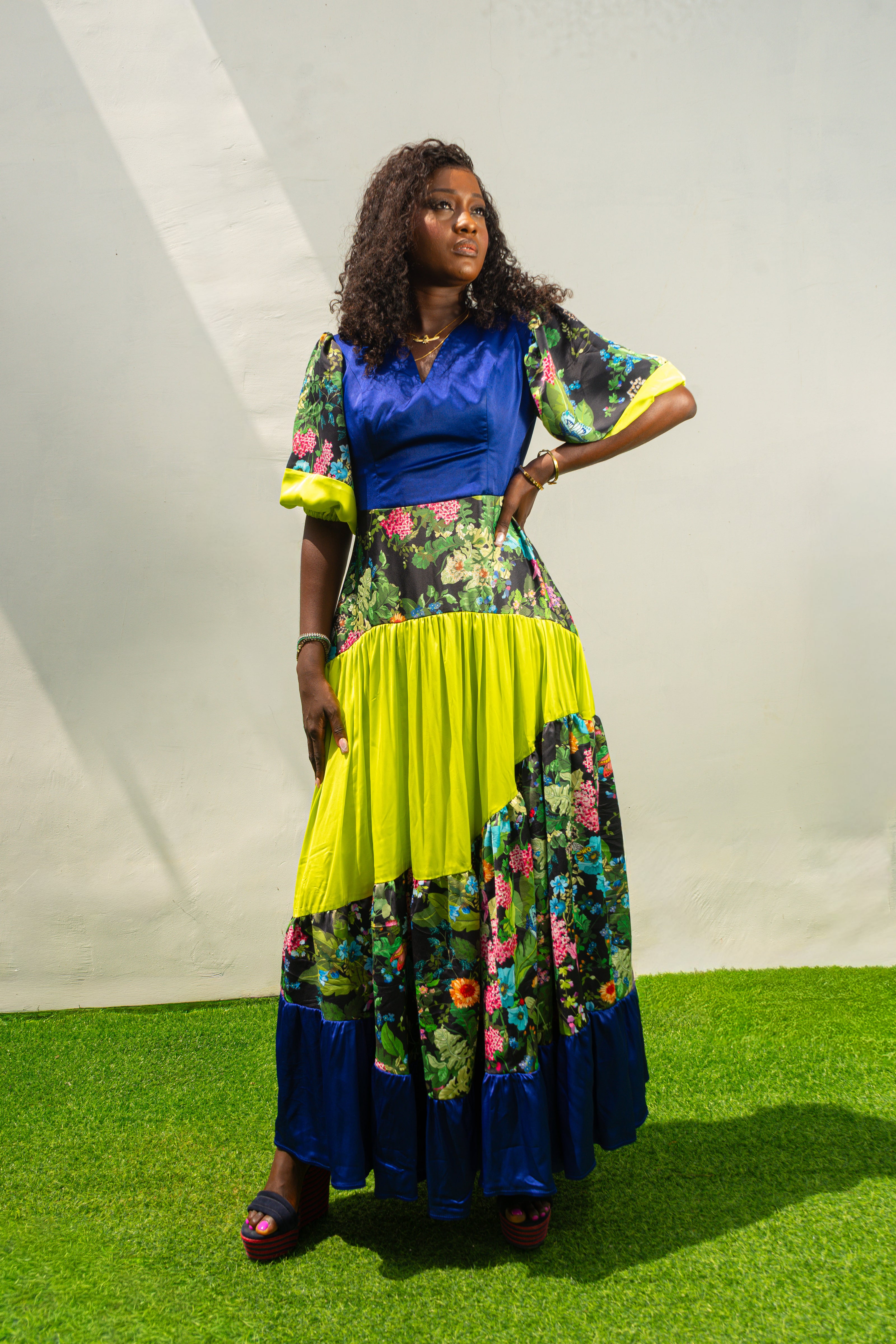 Maxi Dress featuring a solid blue V-neck bodice, floral print sleeves and skirt, and vibrant lime green tiered accents.