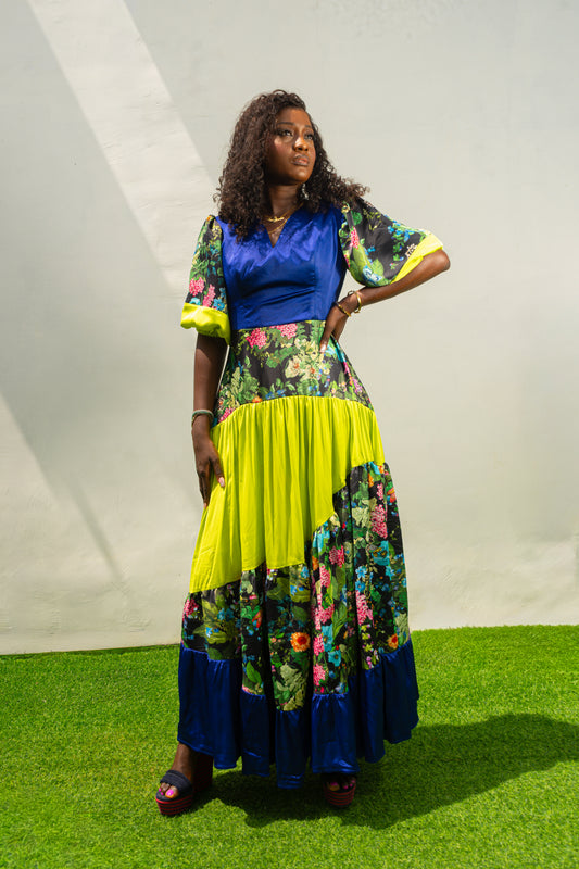 Maxi Dress featuring a solid blue V-neck bodice, floral print sleeves and skirt, and vibrant lime green tiered accents.