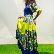 Maxi Dress featuring a solid blue V-neck bodice, floral print sleeves and skirt, and vibrant lime green tiered accents.