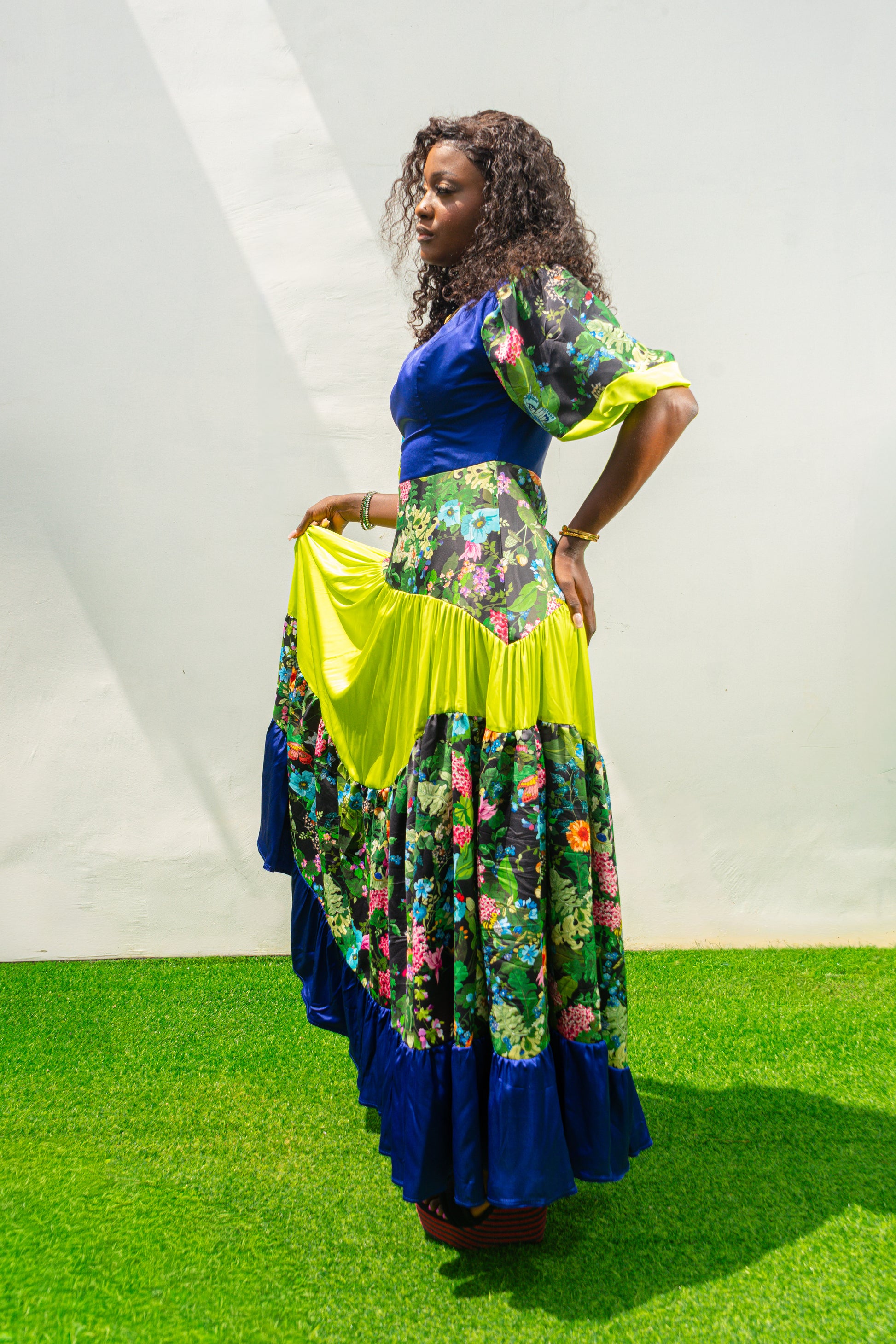 Maxi Dress featuring a solid blue V-neck bodice, floral print sleeves and skirt, and vibrant lime green tiered accents.