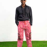 Men's cargo pants featuring a red and white Ankara print, a straight-leg silhouette, and multi-colored striped pocket details.