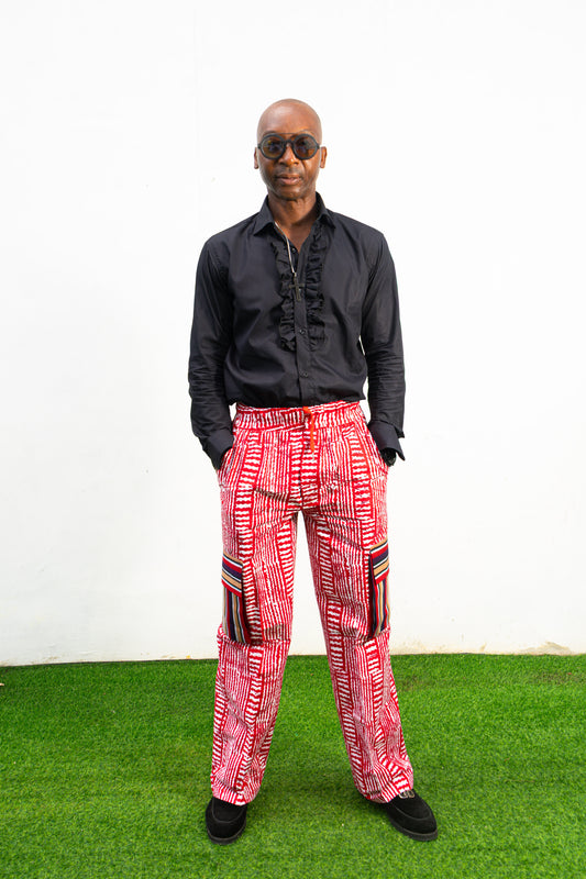 Men's cargo pants featuring a red and white Ankara print, a straight-leg silhouette, and multi-colored striped pocket details.