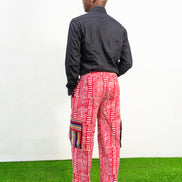 Men's cargo pants featuring a red and white Ankara print, a straight-leg silhouette, and multi-colored striped pocket details.