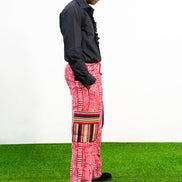 Men's cargo pants featuring a red and white Ankara print, a straight-leg silhouette, and multi-colored striped pocket details.