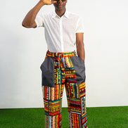 Men's wide-leg pants featuring a vibrant multicolored Ankara patchwork print and oversized grey side pockets.