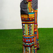 Men's wide-leg pants featuring a vibrant multicolored Ankara patchwork print and oversized grey side pockets.
