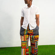 Men's wide-leg pants featuring a vibrant multicolored Ankara patchwork print and oversized grey side pockets.