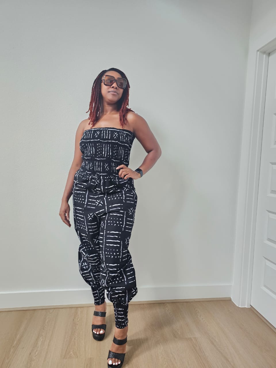 Modern Jumpsuit featuring a strapless, smocked tube bodice and relaxed harem-style pants with side pockets and cinched ankle cuffs, showcased in striking geometric African prints.