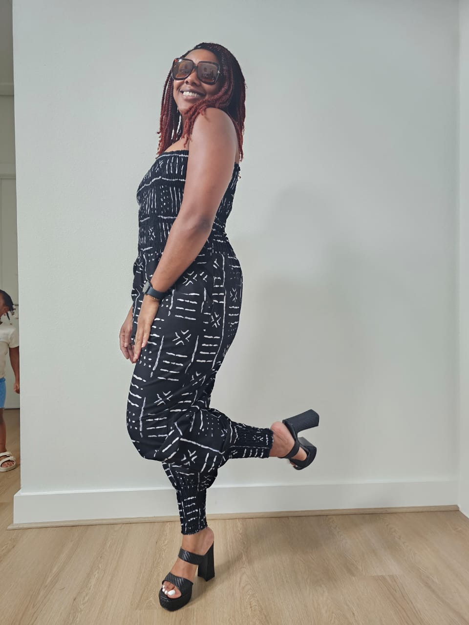 Modern Jumpsuit featuring a strapless, smocked tube bodice and relaxed harem-style pants with side pockets and cinched ankle cuffs, showcased in striking geometric African prints.