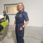 Modern Jumpsuit featuring a deep blue denim fabrication, light-wash contrast trim details on the short sleeves, back yoke, and curved utility pockets, complete with a structured mandarin collar and a front zip closure.