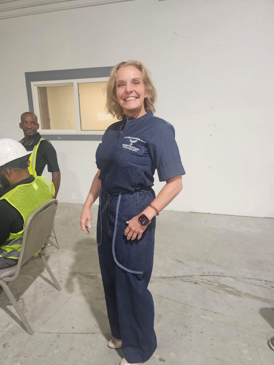Modern Jumpsuit featuring a deep blue denim fabrication, light-wash contrast trim details on the short sleeves, back yoke, and curved utility pockets, complete with a structured mandarin collar and a front zip closure.
