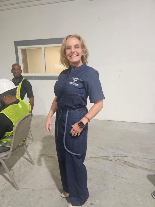Modern Jumpsuit featuring a deep blue denim fabrication, light-wash contrast trim details on the short sleeves, back yoke, and curved utility pockets, complete with a structured mandarin collar and a front zip closure.