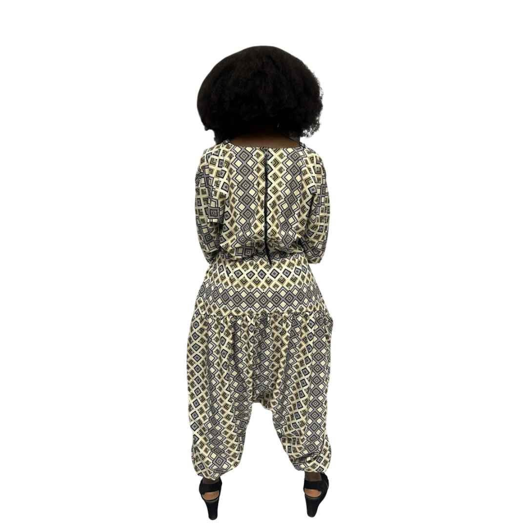 Palazzo Jumpsuit featuring a cream and black geometric diamond print, an embellished V-neckline, and a voluminous drop-crotch silhouette.