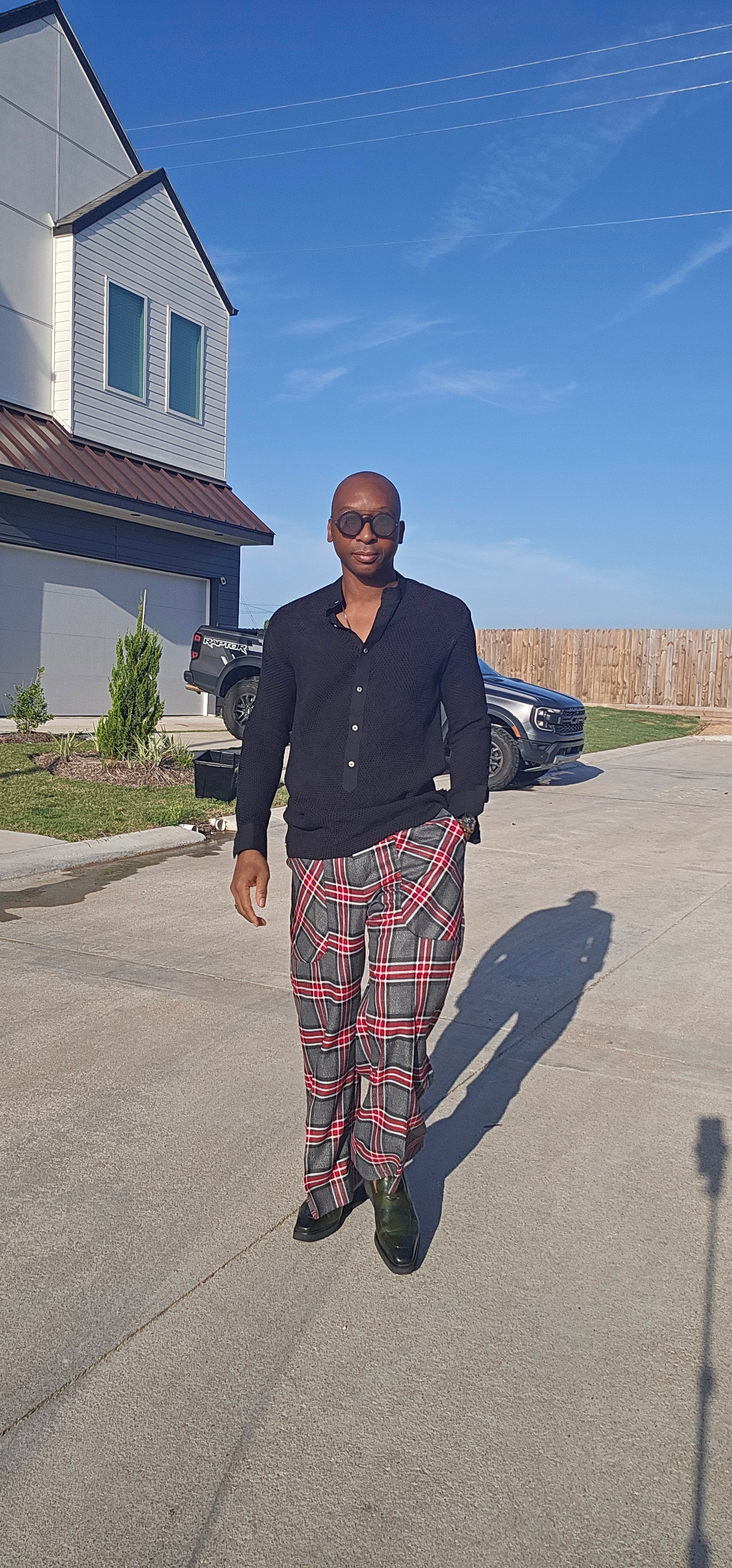 Flared Pants featuring a gray, black, and red plaid pattern with a wide flared leg silhouette and angled patch hip pockets.