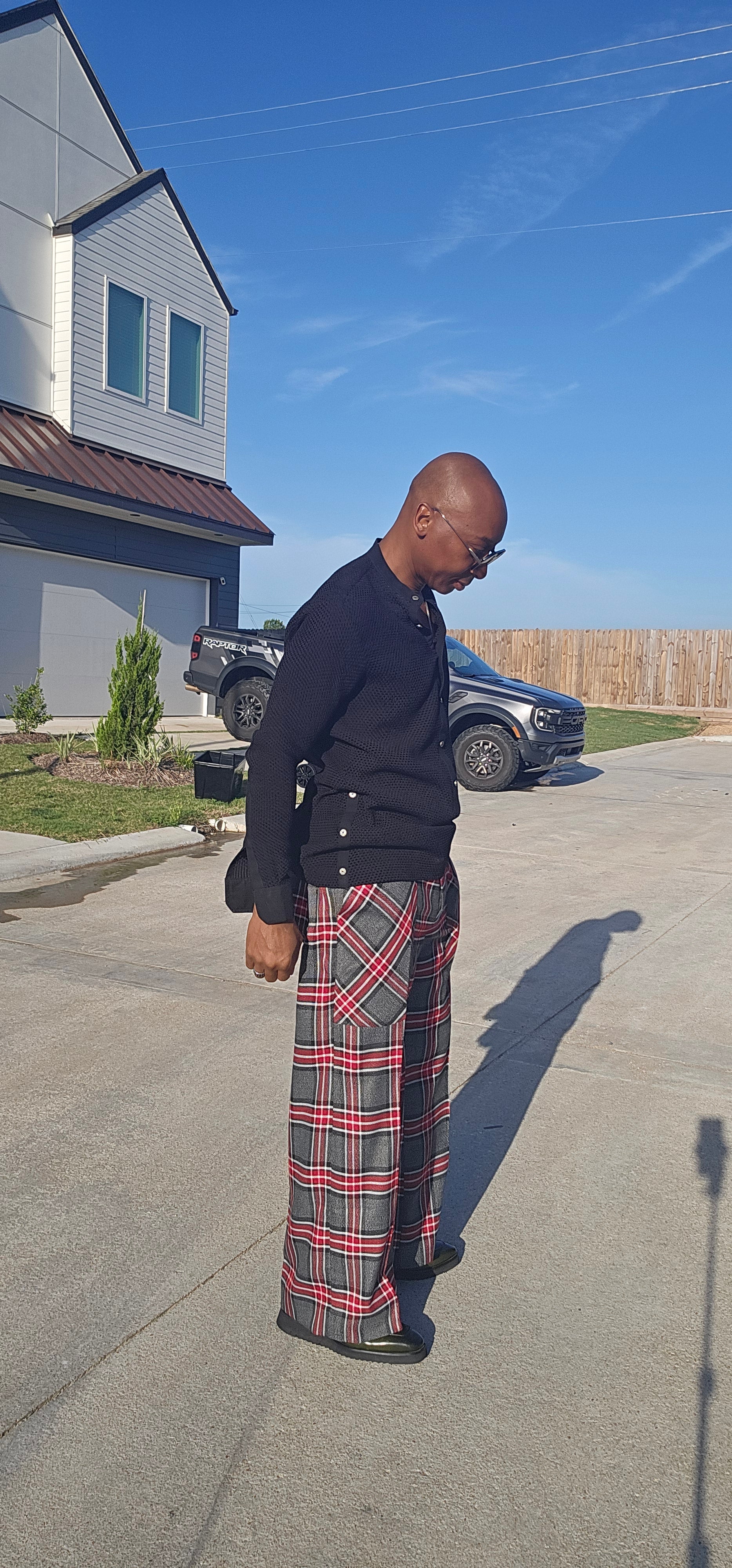 Flared Pants featuring a gray, black, and red plaid pattern with a wide flared leg silhouette and angled patch hip pockets.