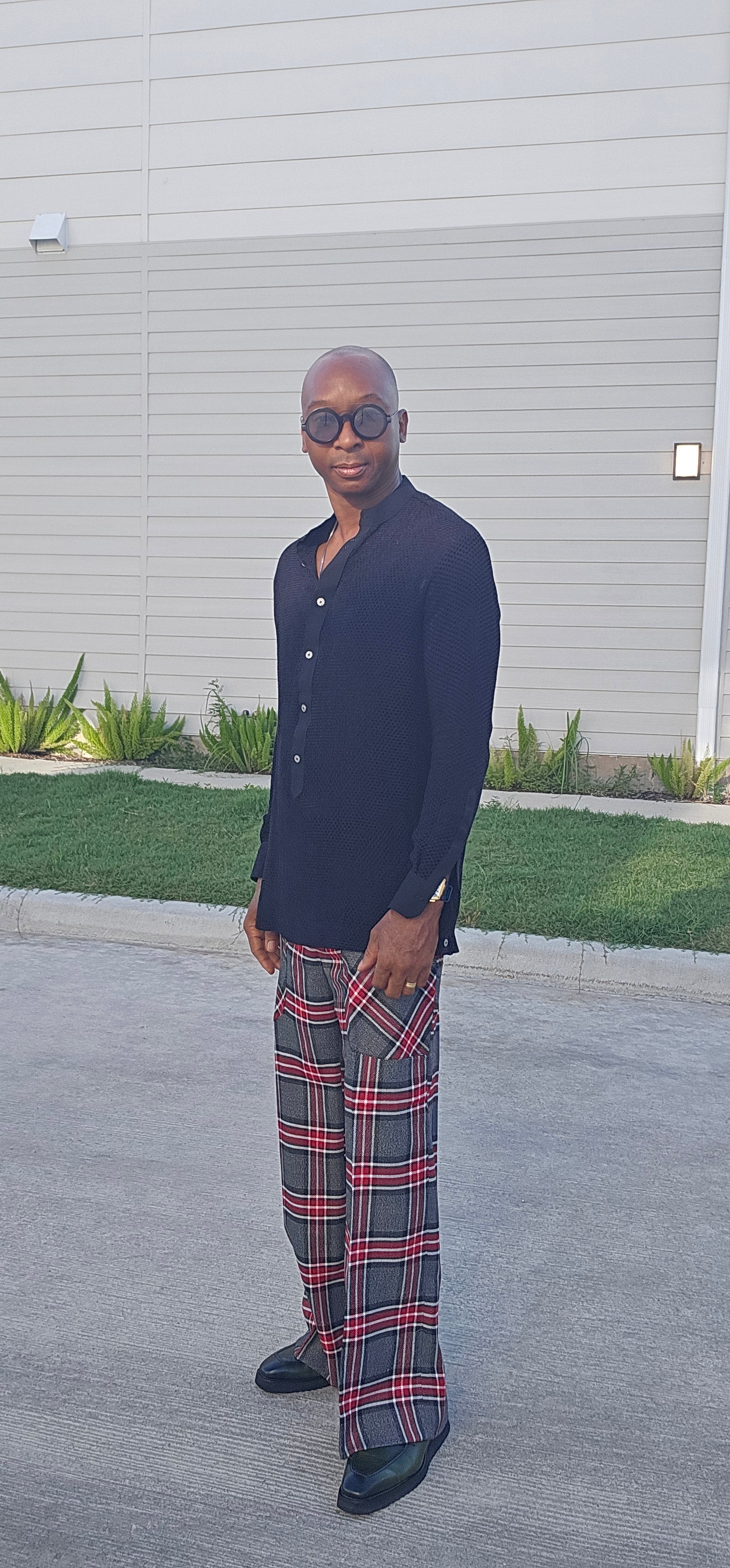 Flared Pants featuring a gray, black, and red plaid pattern with a wide flared leg silhouette and angled patch hip pockets.
