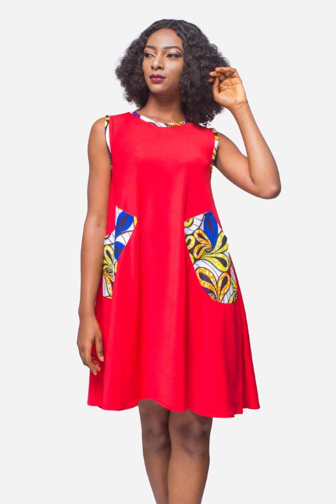 Shift Dress featuring a sleeveless, flowing red jersey mini dress accented with colorful geometric African print accents at the shoulders and large curved side patch pockets