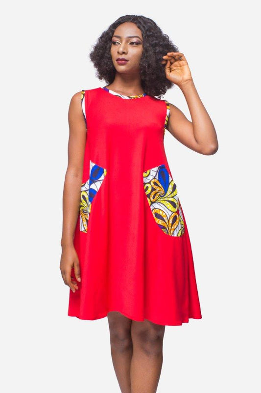 Shift Dress featuring a sleeveless, flowing red jersey mini dress accented with colorful geometric African print accents at the shoulders and large curved side patch pockets