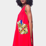 Shift Dress featuring a sleeveless, flowing red jersey mini dress accented with colorful geometric African print accents at the shoulders and large curved side patch pockets